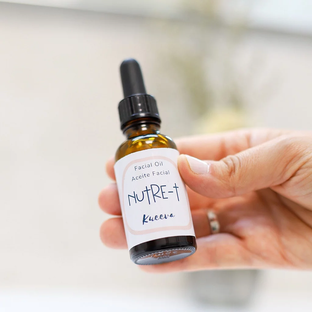 Botellita de aceite facial cogida con las manos
